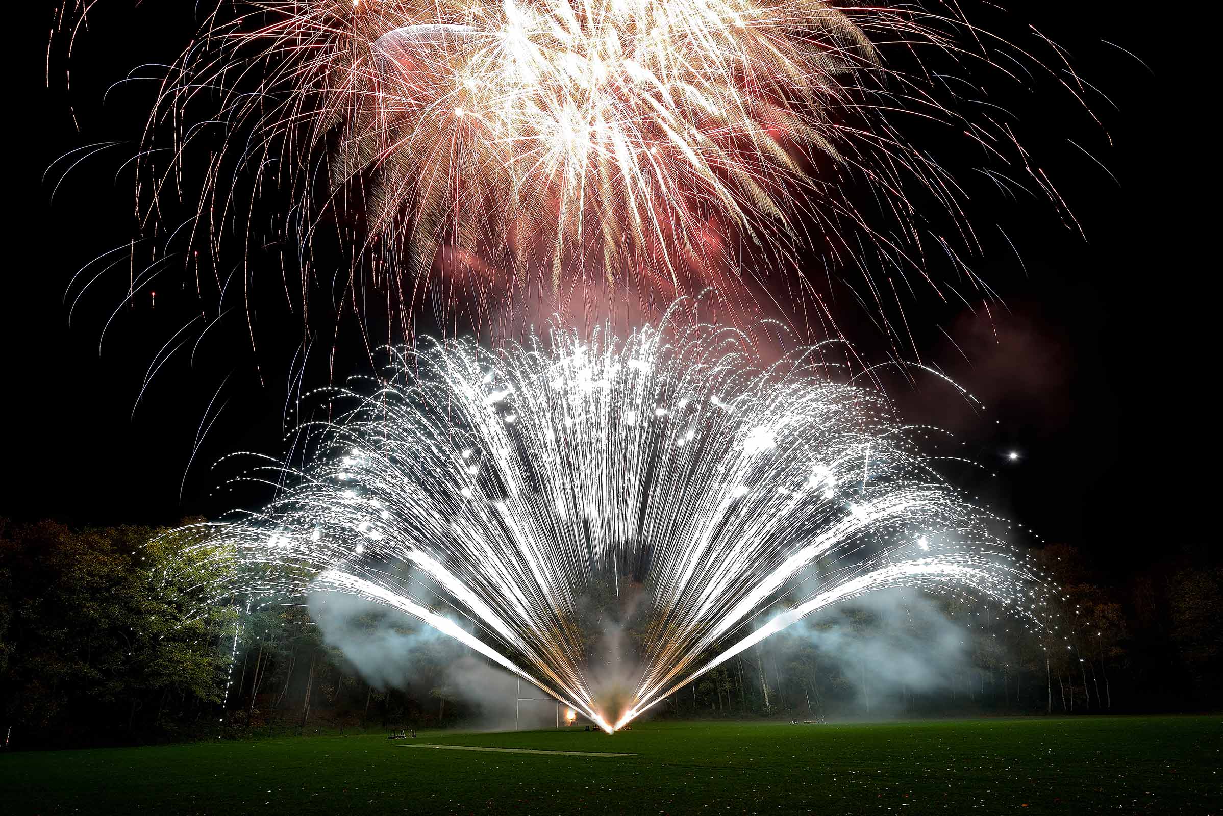 Bride and groom silhouetted against a pyromusical finale